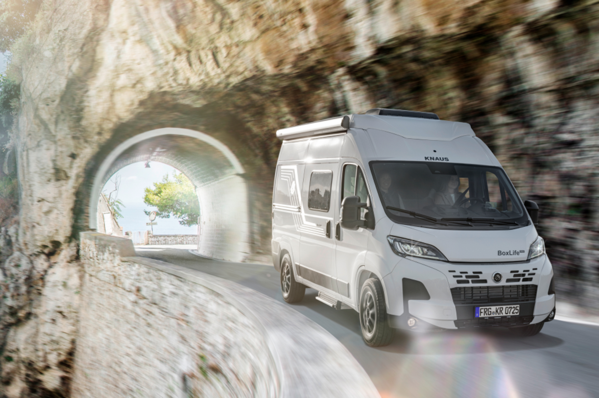 Ein Kastenwagen von KNAUS fährt eine Serpentinenstraße entlang.