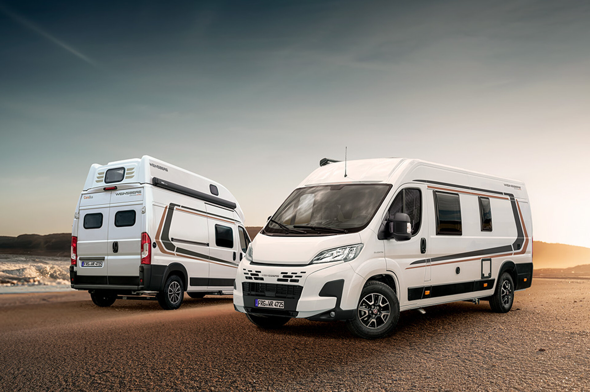 Pohled zepředu a zezadu: Dva speciální modely CaraBusů jsou zaparkované v poušti na slunci.