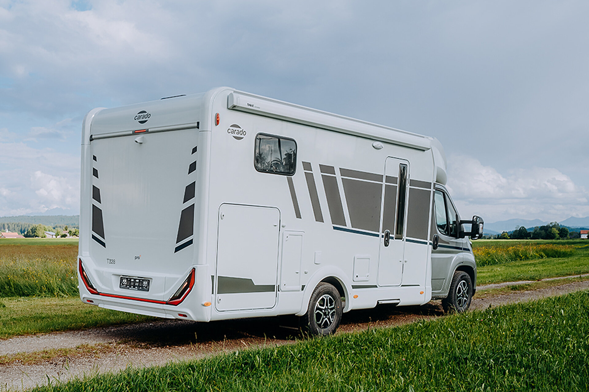 Pohled zezadu na Carado T328, který parkuje na venkovské silnici uprostřed přírody.