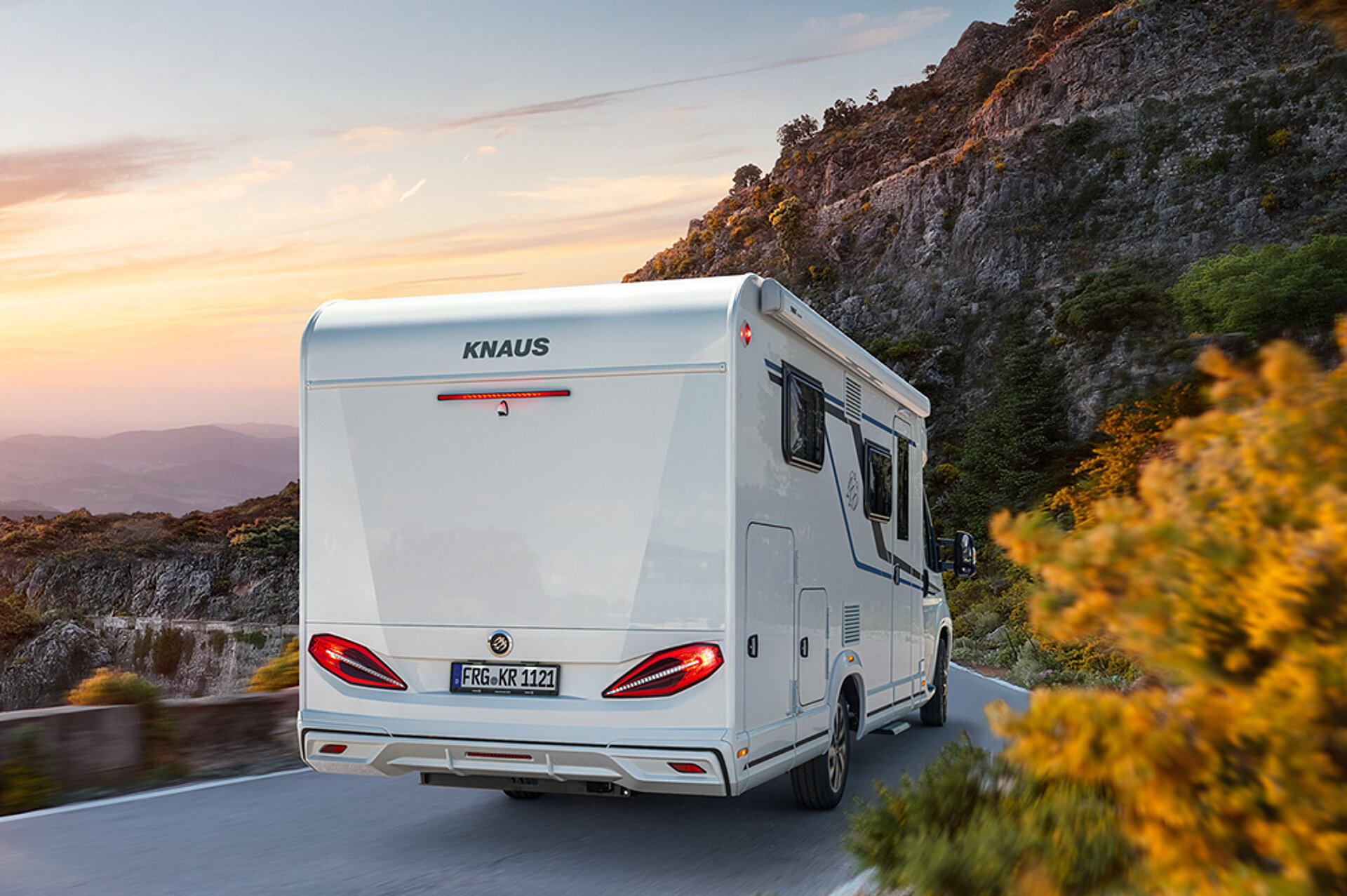 KNAUS VAN TI jede po silnici směrem k západu slunce.