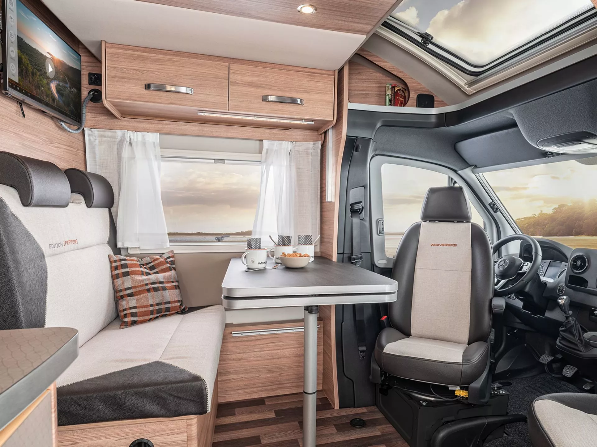 Die Sitzgruppe mit Tisch in einem Wohnmobil, die Fahrersitze sind umgedreht zum Tisch