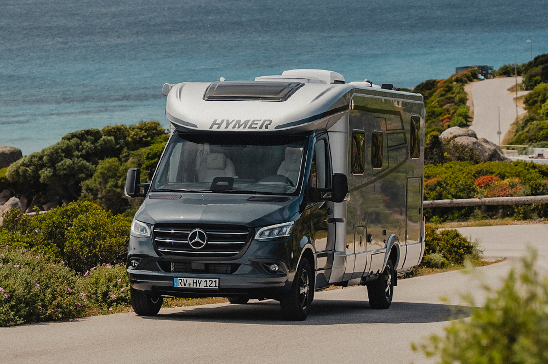Entdecken Sie den neuen HYMER B-MC T! Eine HYMER B-Klasse ModernComfort T fährt eine Küstenstraße auf Sardinien entlang.