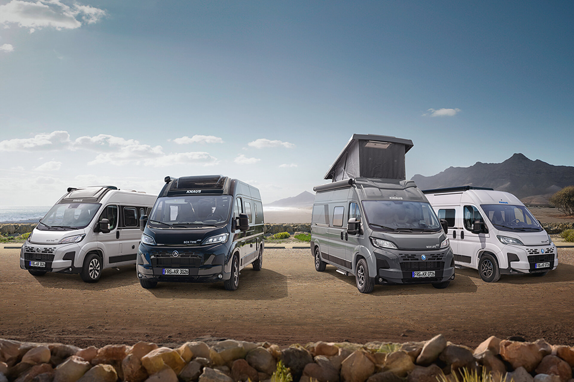 Alle Kastenwagen-Baureihen von KNAUS stehen auf einem Parkplatz nebeneinander.