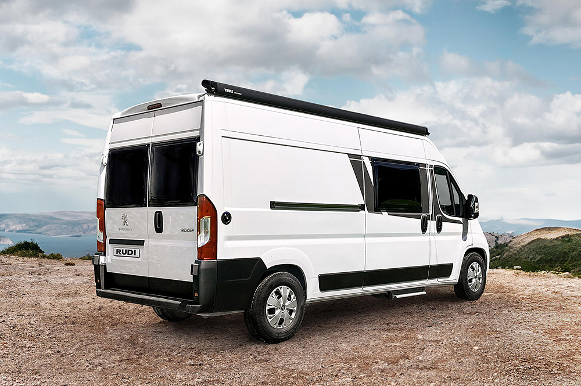 Pohled zezadu na dodávku Carado CV600 zaparkovanou u útesu.