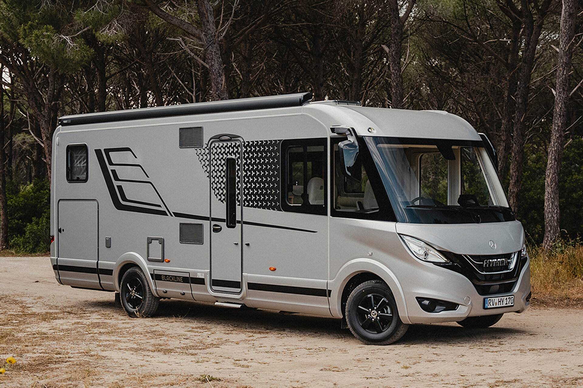 Die BlackLine punktet mit noch mehr Ausstattung und exklusivem Design. Ein HYMER B-ML I in BlackLine-Sonderedition parkt auf einem Platz vor einem Wald.