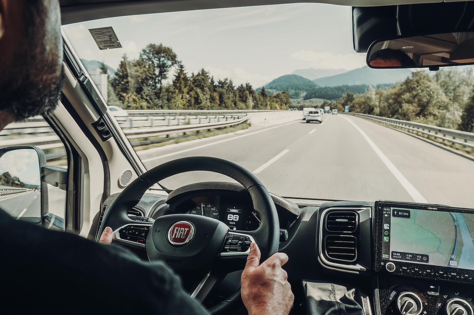 Pohled z kokpitu letounu T457 na dálnici, na které jede muž.