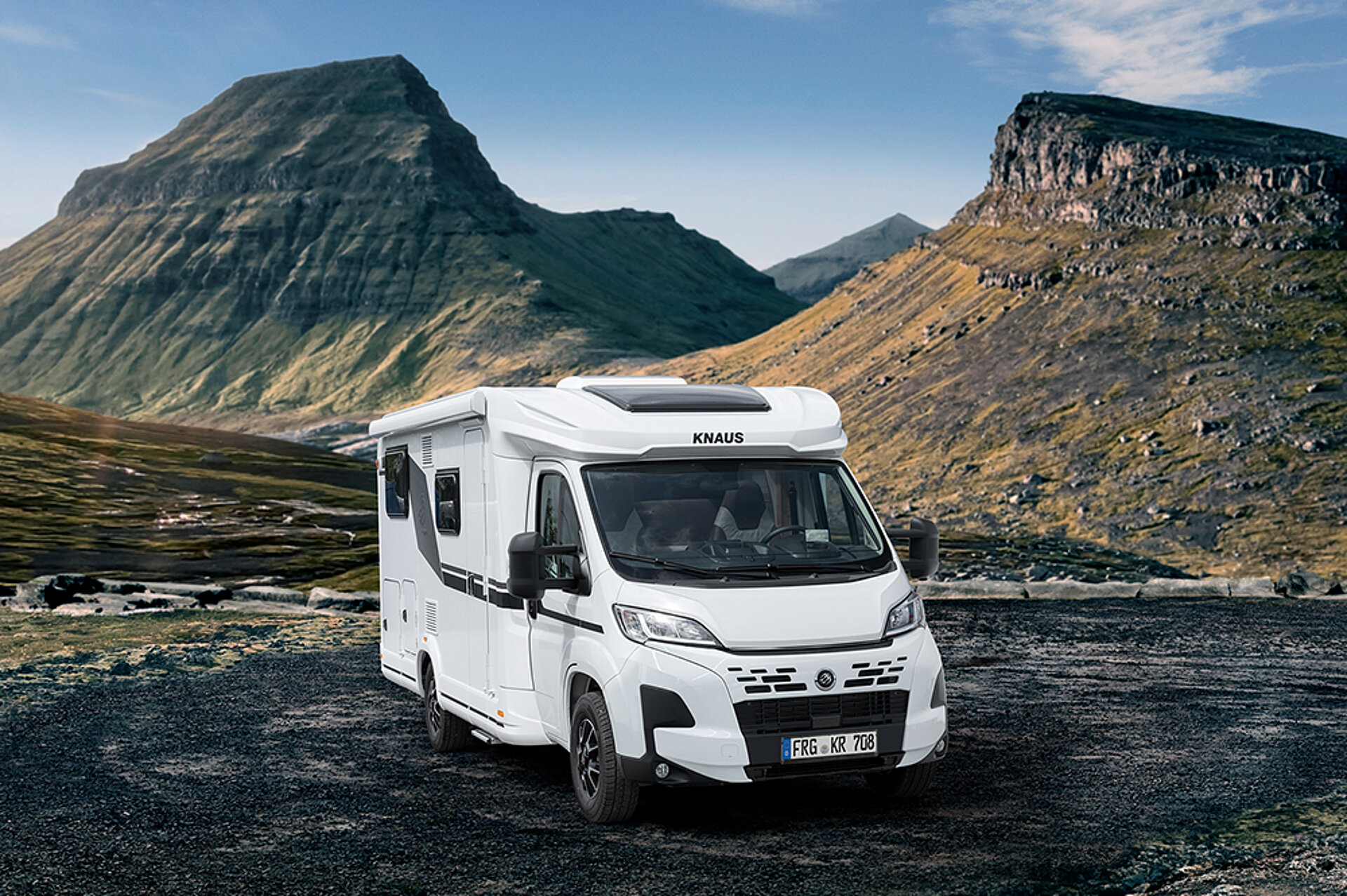 Ein KNAUS L!VE TI PLATINUM SELECTION steht in einer malerischen Berglandschaft.