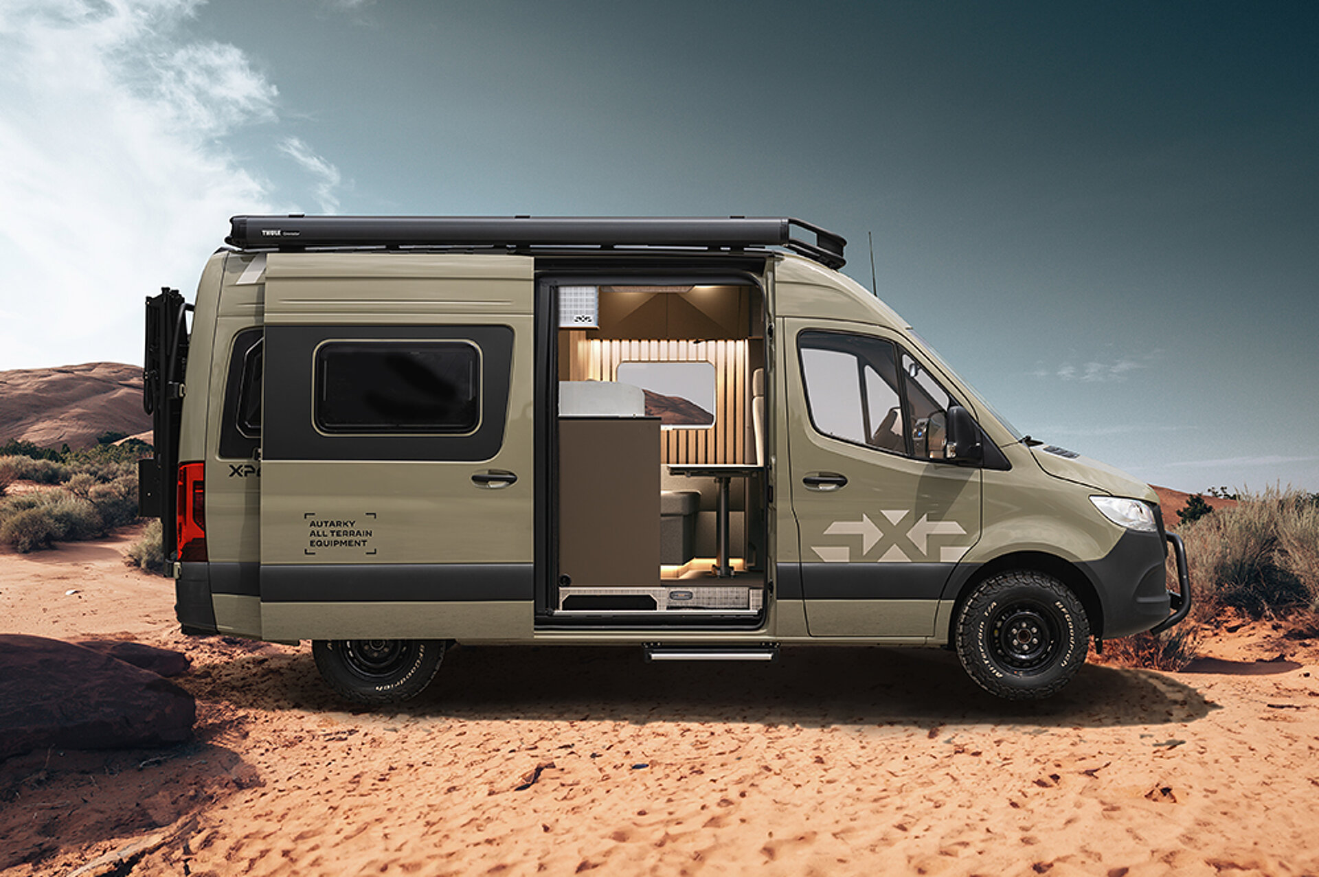 Boční pohled na X-PEDITION s otevřenými posuvnými dveřmi, stojící v poušti.