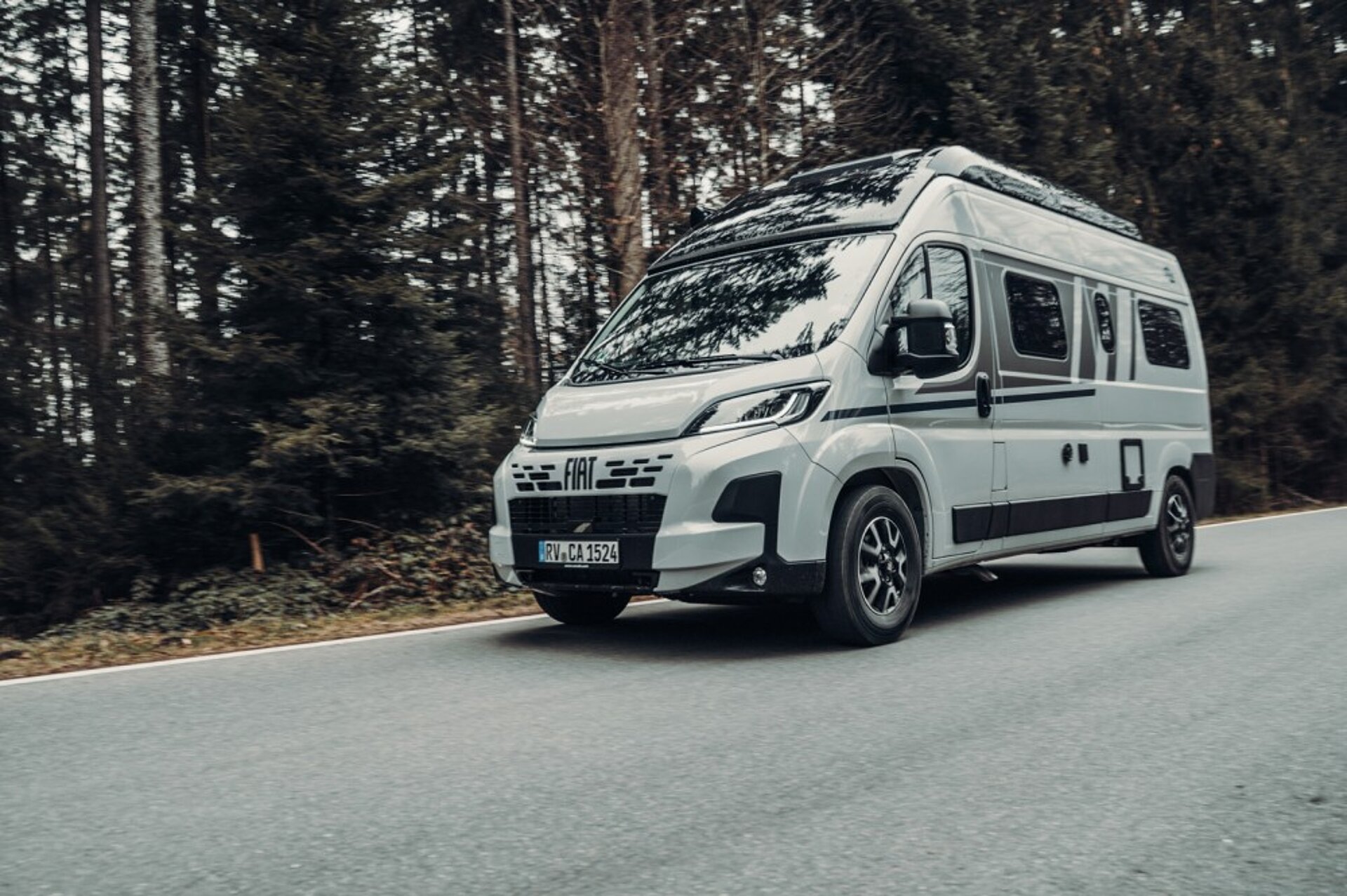 Ein Carado Camper Van fährt eine Straße entlang.