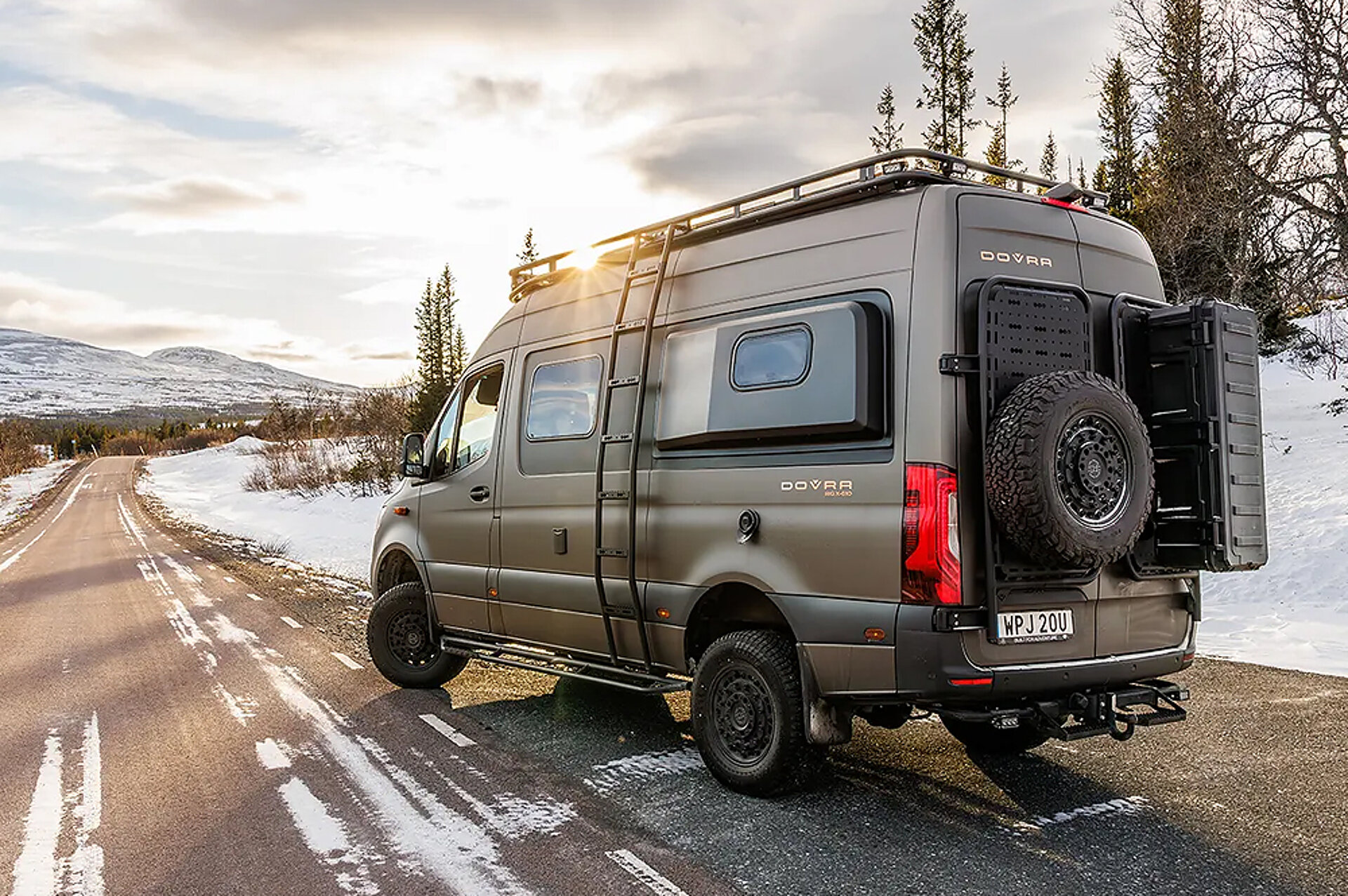 Heckansicht eines Dovra Offroad Kastenwagens, der an einer Straße in einer Winterlandschaft parkt.