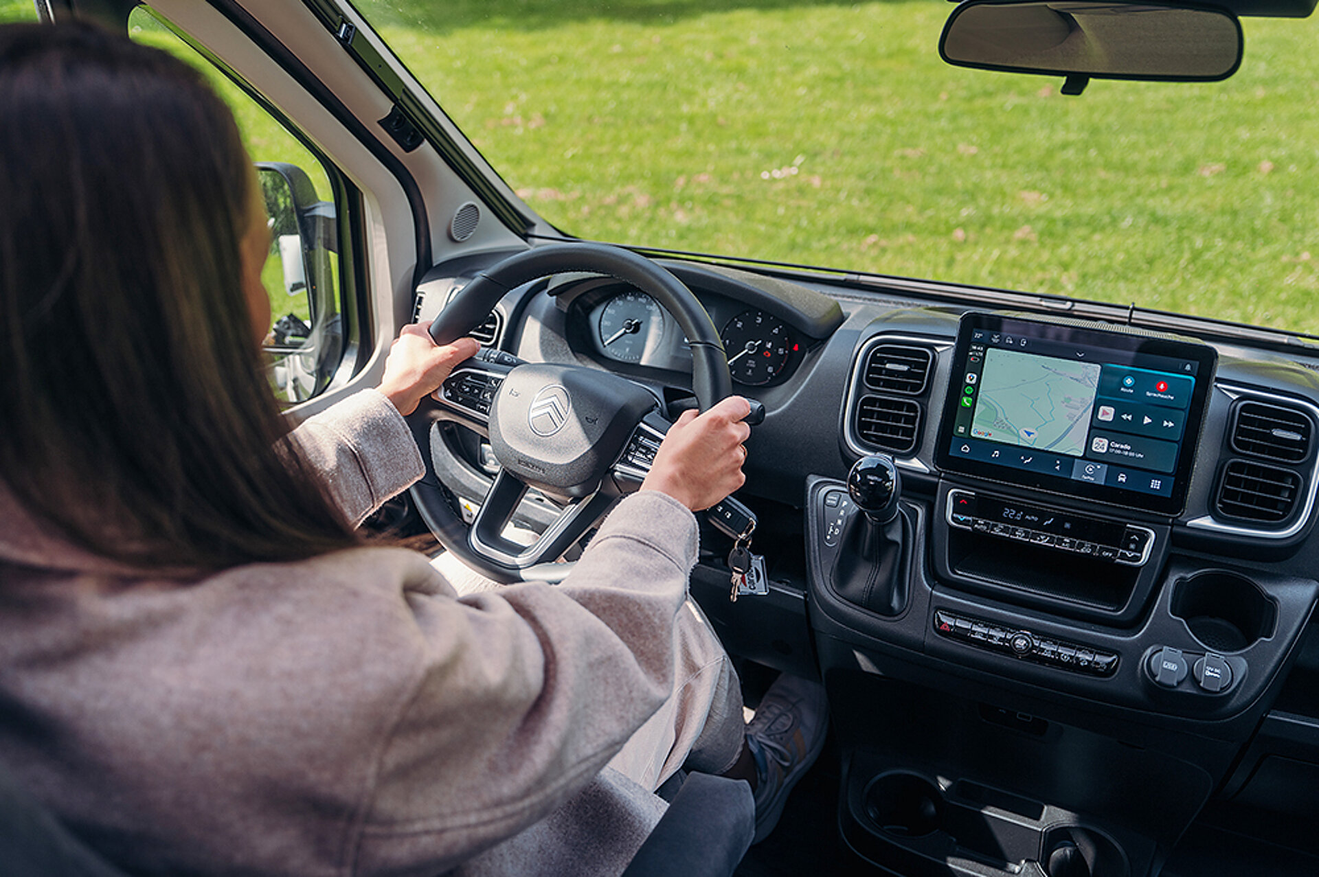 Pohled z kokpitu letadla V347, za řídicími pákami sedí žena.