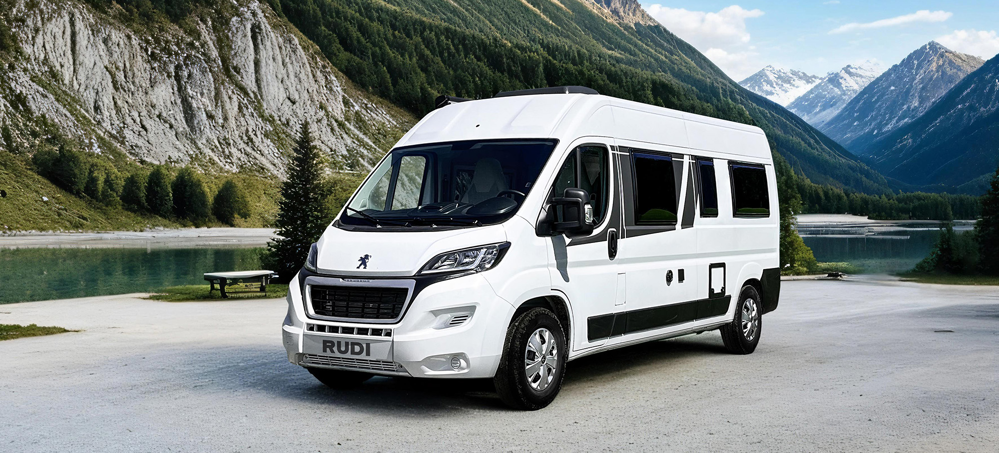 Pohled zepředu na obytný vůz Carado CV600, který parkuje u horského jezera.