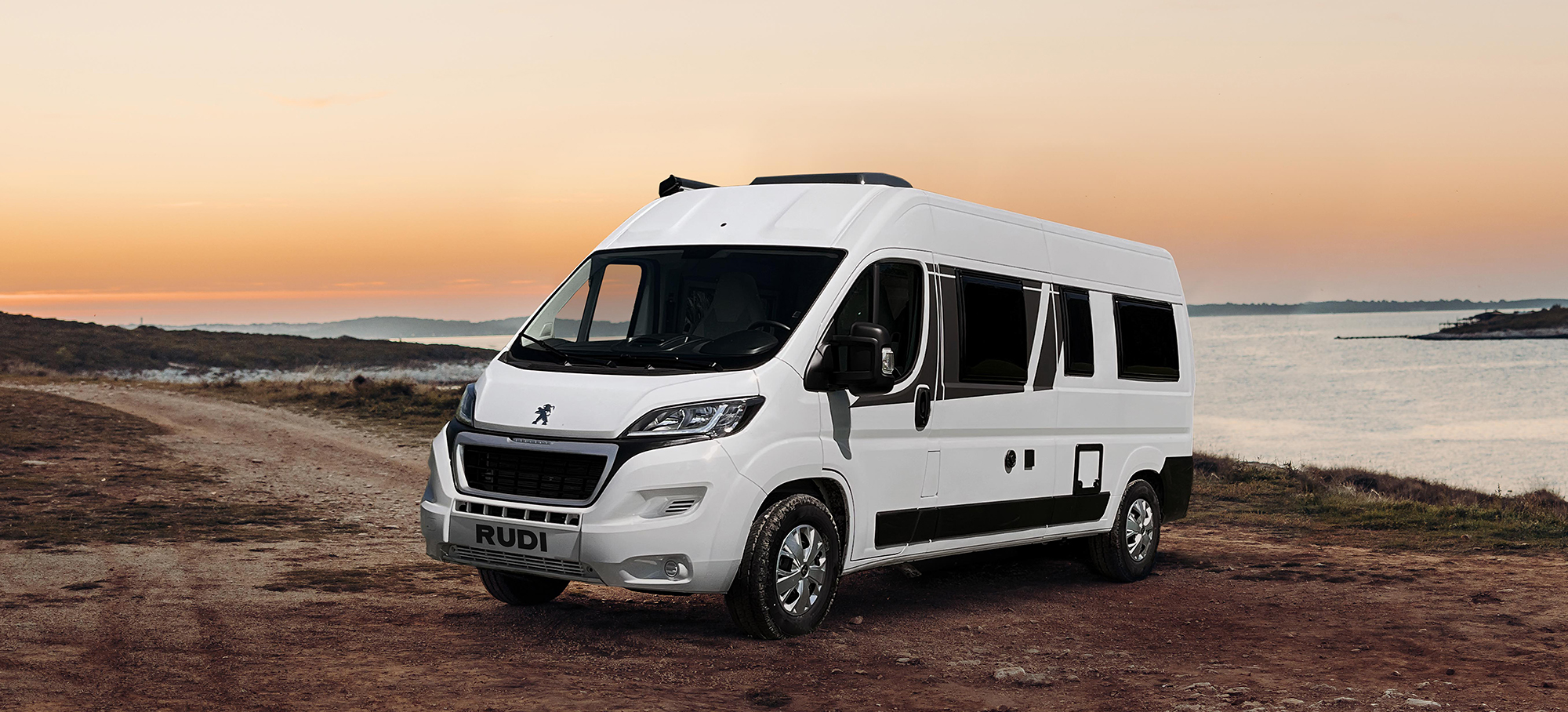 Frontansicht auf den Carado CV640 Camper Van an einer Klippe im Abendlicht.