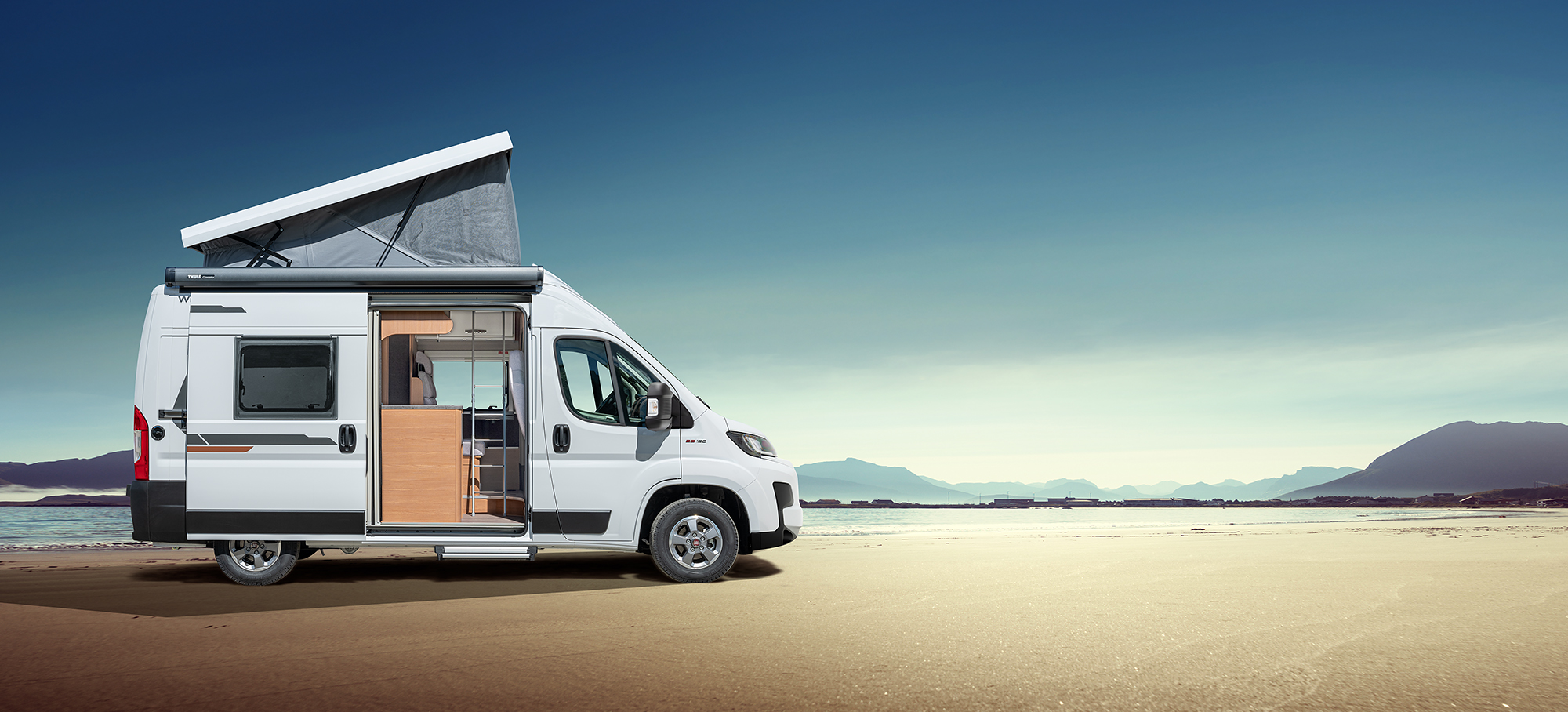 Boční pohled na WEINSBERG CaraBus na slunné pláži.