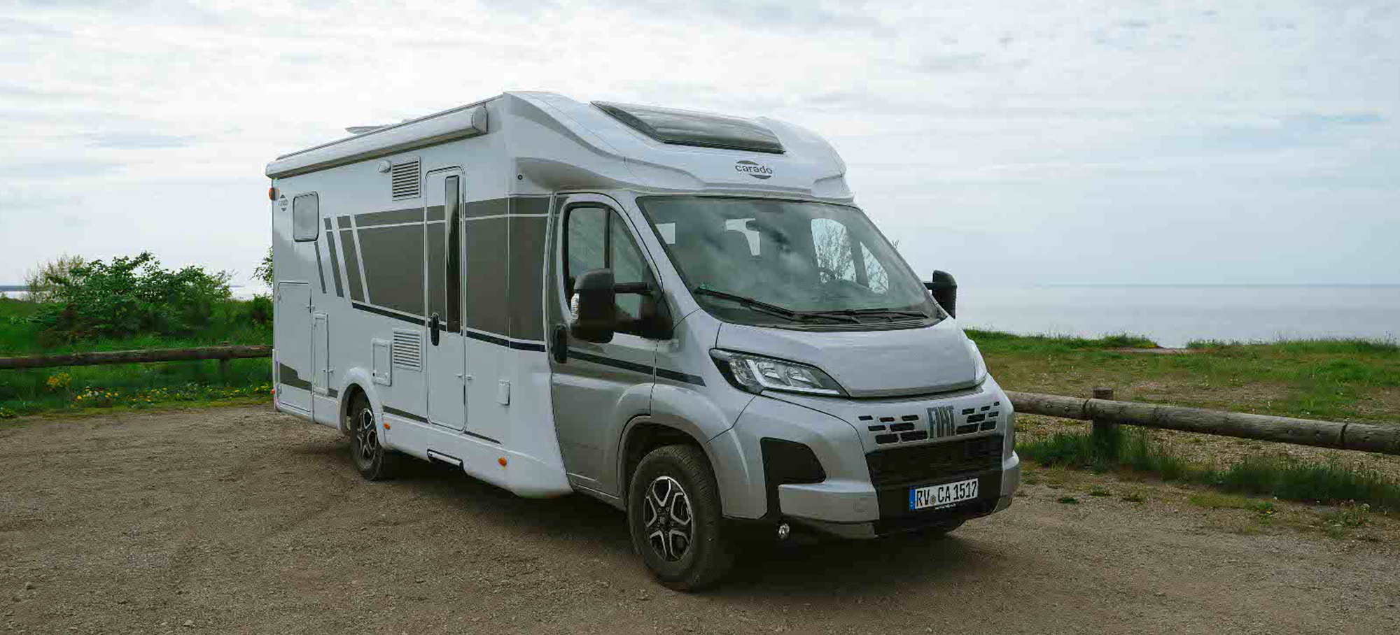 Carado T447 stojí pod zamračenou oblohou na parkovišti s popelem.