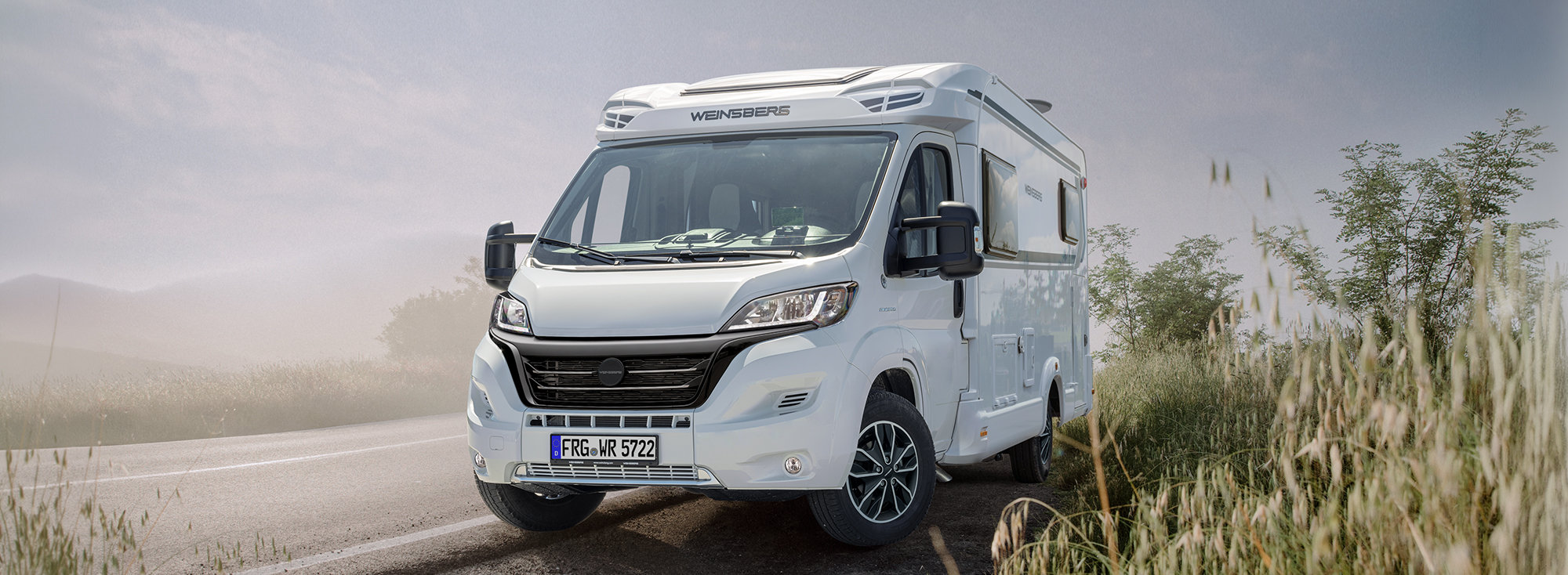 Ein WEINSBERG Wohnmobil parkt am Straßenrand.