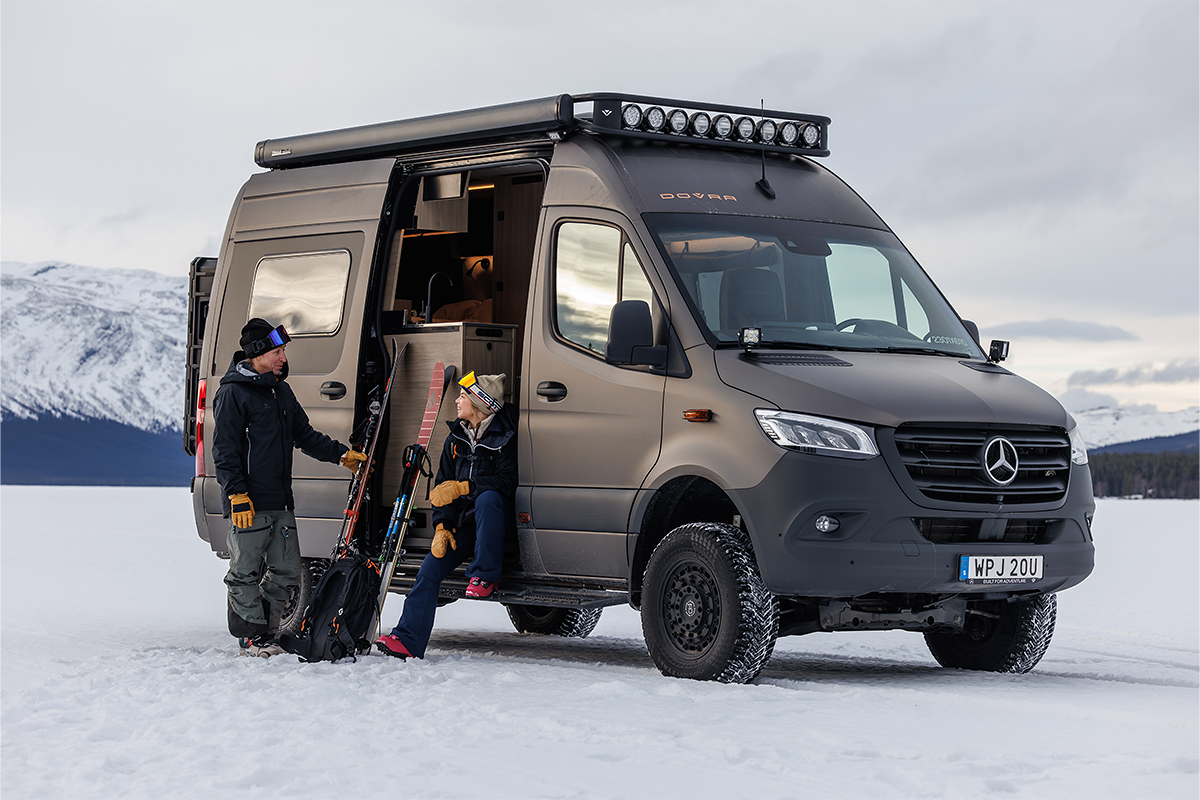 Dovra Offroad-Camper – gemacht für Abenteuer Zwei Menschen sitzen an der Seitentür eines Dovra Offroad-Campers.